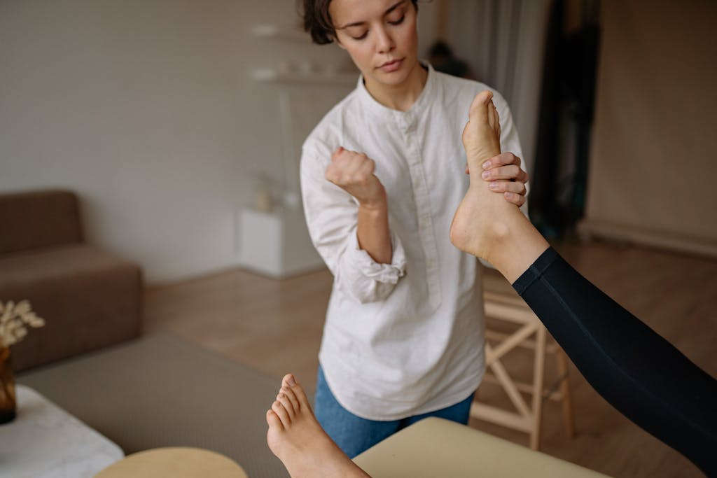 A massage therapist gives a relaxing foot therapy session in a calm indoor setting.